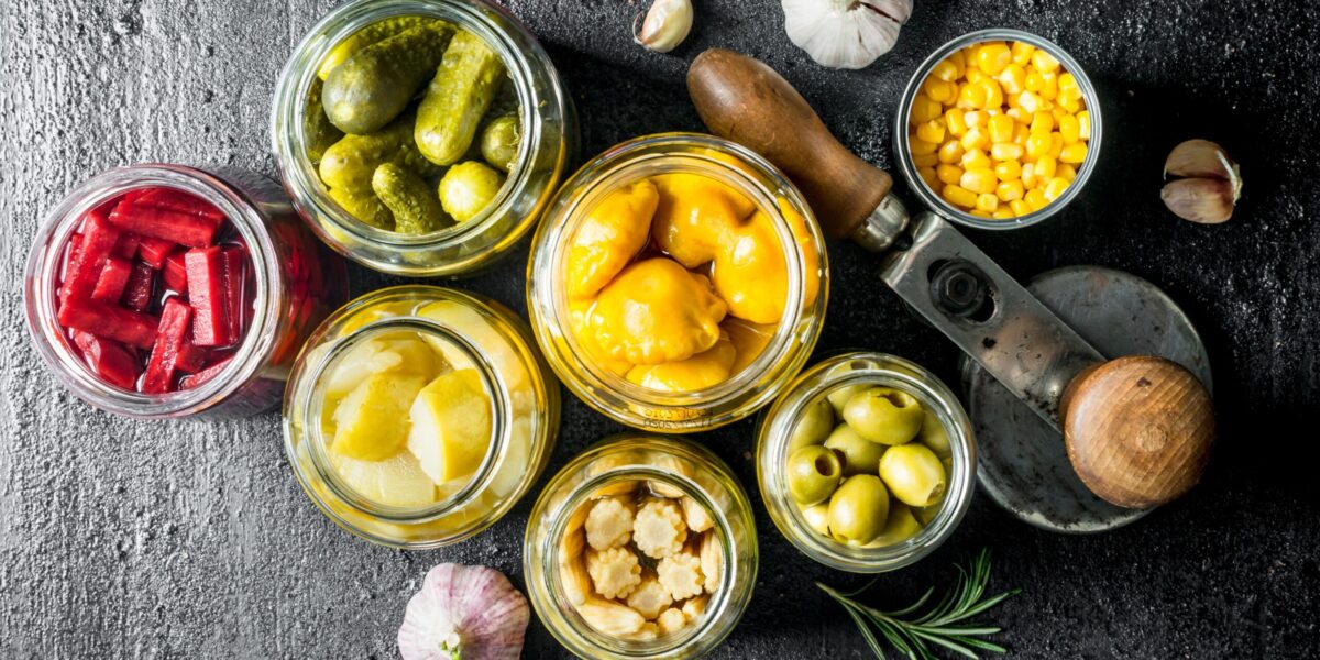 Pickled vegetables in glass jars. On black rustic background SSUCv3H4sIAAAAAAAEAJ2RS27DIBCG95V6B4t1LPmRuHavEnUxBhyjYIgAt7Ii372DCdWsKzbMN89/5vn+VhRsBK84+yye0UJbab364CAoaxBXpxd30gjpKJFCBesUaApHCHw2sEiEZtU64v1wMh8grF762OyFOAR5wxoJ/pVIE12TXWTH4cQMdDF2Isyv48Ey2k//zkyfr6wGbtLw7RiYCHFSS0hCrimU3X+CdAuVBqtQlqj6thx0DGhJpYdTXJkbSbNhPrac07hdTXAbnZxpax8w6rjiCWvKzGfwHsNF5qQRx5vahfQxNhwCXlWZwEtEs26bqq2Hrmo/mkvTdf3A8vUsvytBJaaDzgpdbiNcxQnYMAJA3U4lNBdRns81lEPf4q9v8MEZxNTj4vdfYL2Uj4cCAAA=